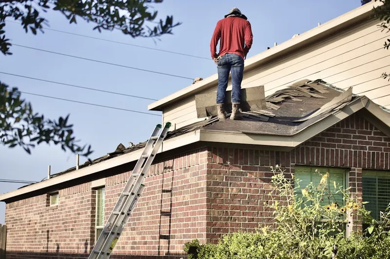 Professional roofer working on a residential roof in Duxbury